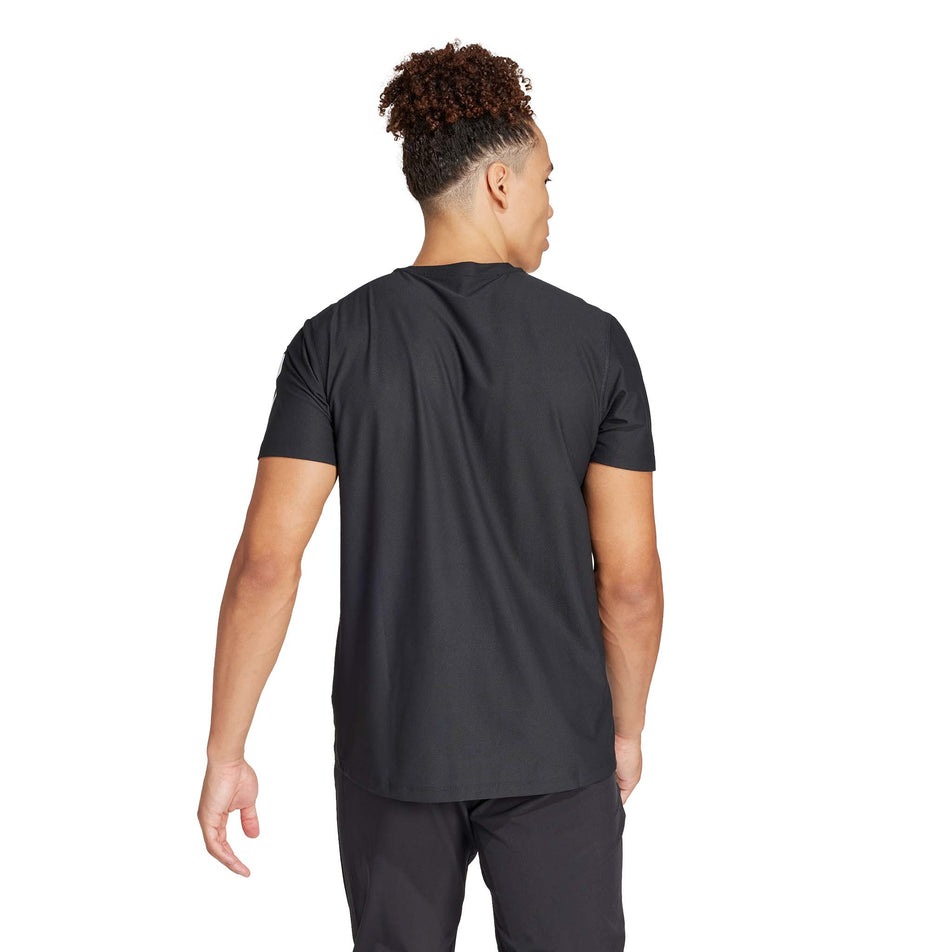 Back view of a model wearing the adidas Men's Own The Run Base Tee in the Black colourway.  (8566972317858)