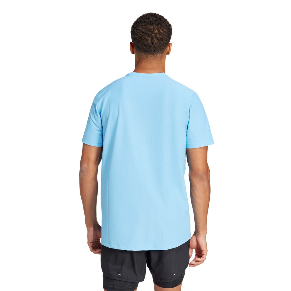 Back view of a model wearing an adidas Men's Own The Run T-Shirt in the Semi Blue Burst colourway. Model is also wearing adidas shorts. (8312074961058)