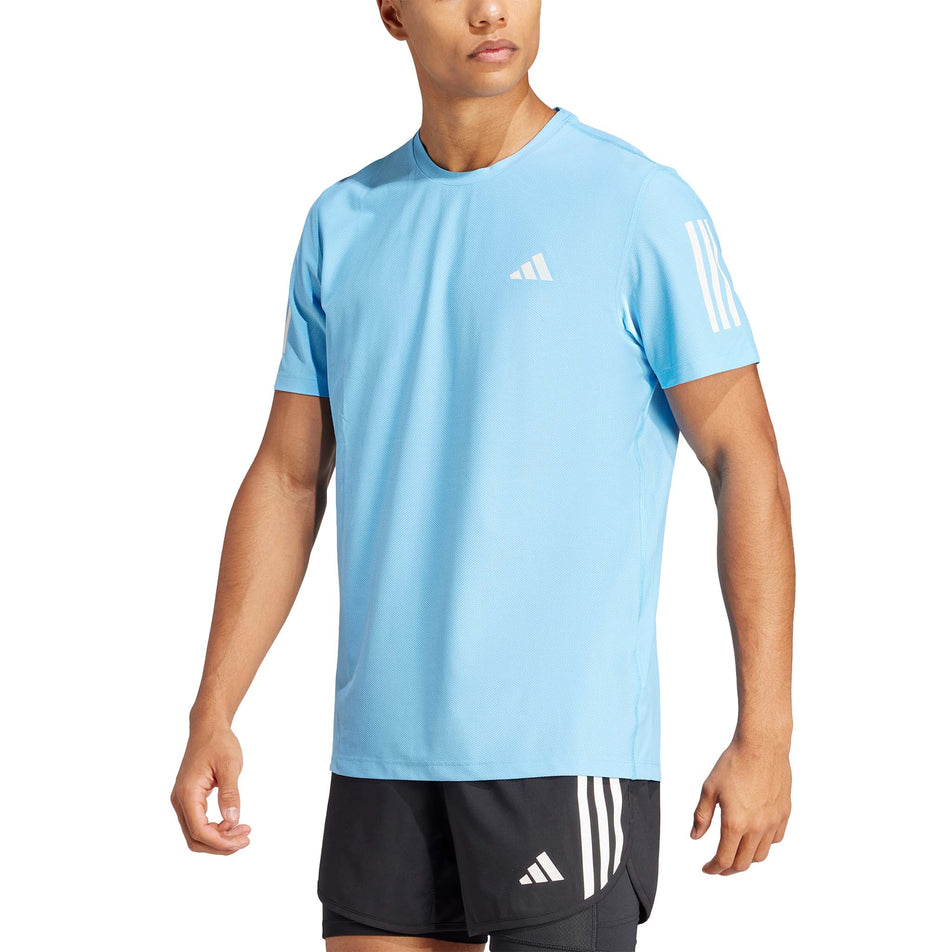 Front view of a model wearing an adidas Men's Own The Run T-Shirt in the Semi Blue Burst colourway. Model is also wearing adidas shorts. (8312074961058)