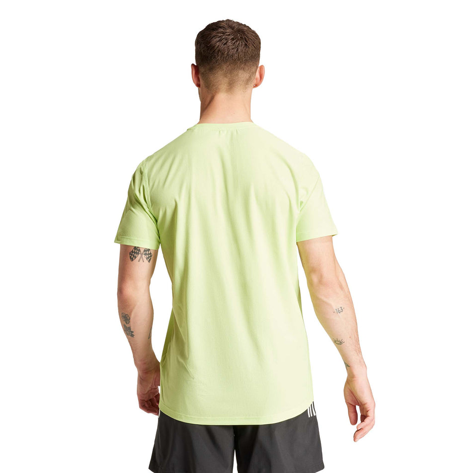 Back view of a model wearing the adidas Men's Own The Run Base Tee in the Pulse Lime colourway. (8566977003682)