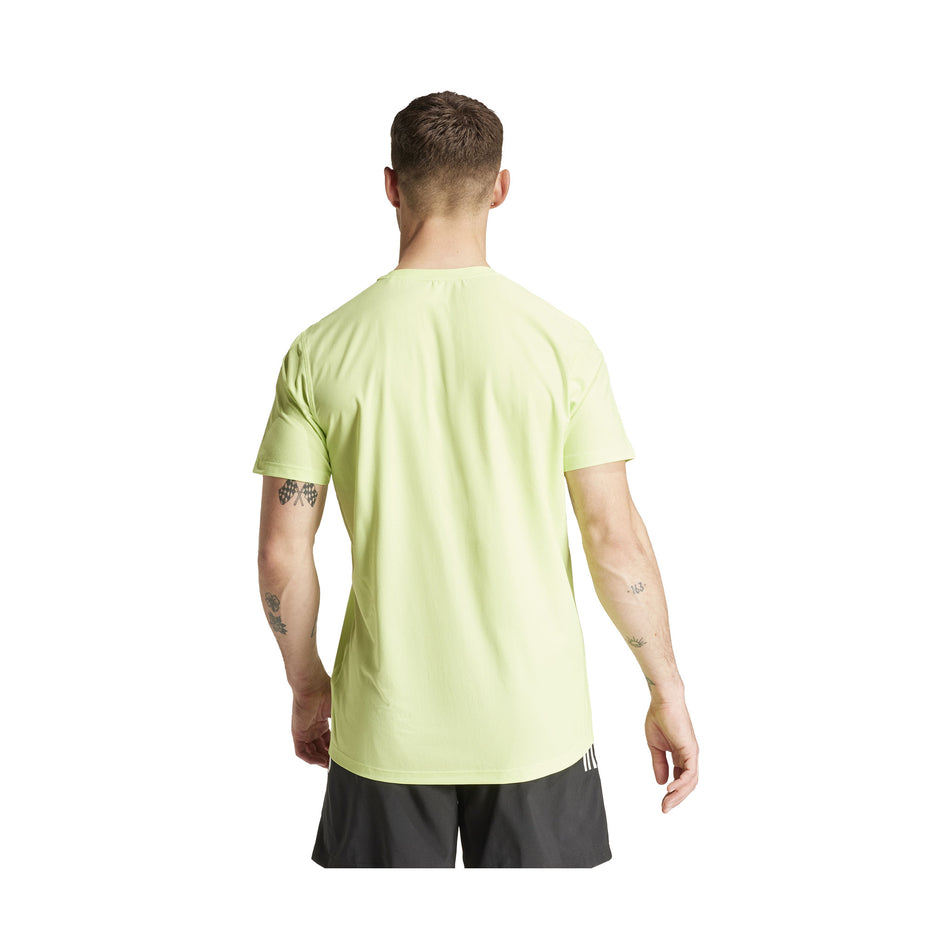 Back view of a model wearing an adidas Men's Own The Run T-Shirt in the Pulse Lime colourway. Model is also wearing adidas shorts. (8457446949026)