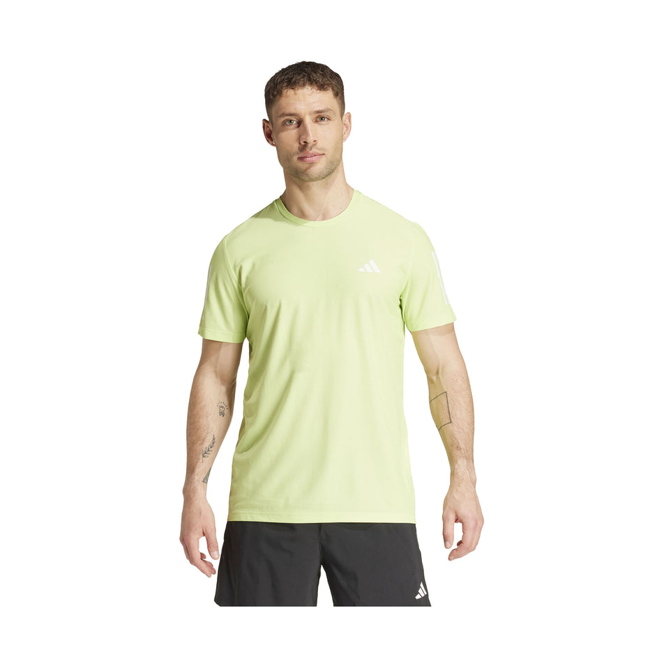 Front view of a model wearing an adidas Men's Own The Run T-Shirt in the Pulse Lime colourway. Model is also wearing adidas shorts. (8457446949026)