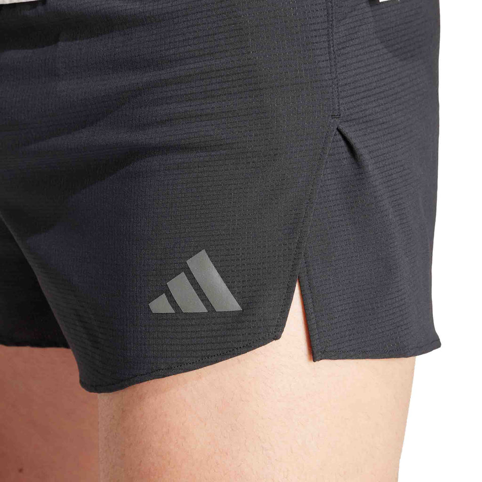 Close-up view of the lower left-side of a pair of adidas Men's Adizero Running Gel Short in the black colourway. Shorts are being worn by a model. (8449511850146)