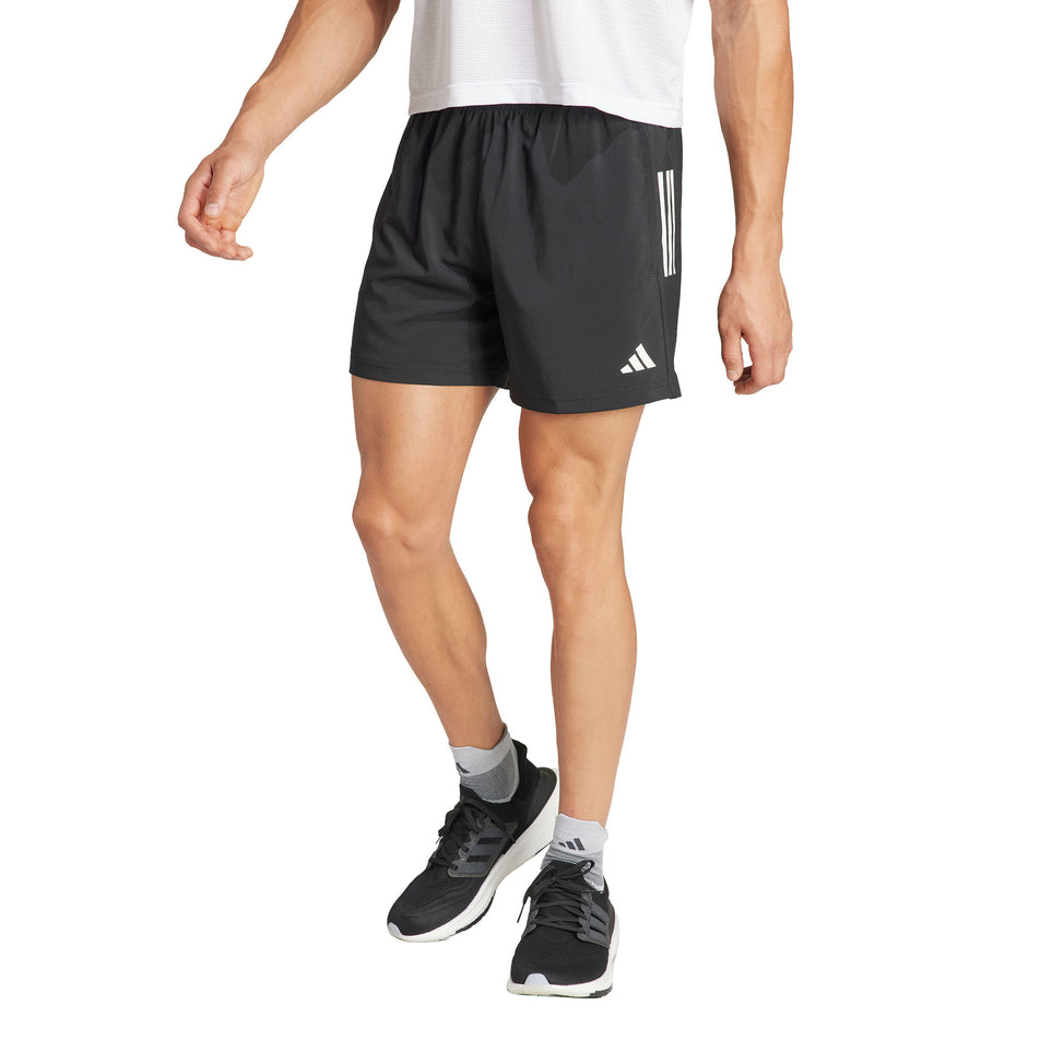 Front view of a model wearing the adidas Men's Own The Run Base Short in the Black colourway. (8567004004514)