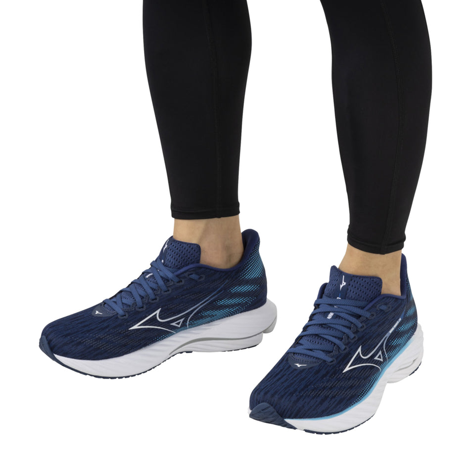 A model wearing a pair of Mizuno Men's Wave Rider 28 Running Shoes in the Estate Blue/White/River Blue colourway (8339276103842)