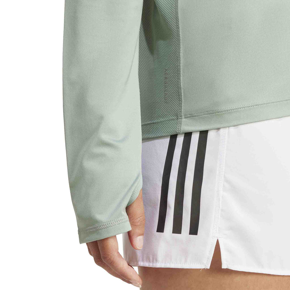 The thunbloop on the sleeve of the adidas Women's Own The Run Base Half Zip in the Silver Green colourway. (8567465181346)