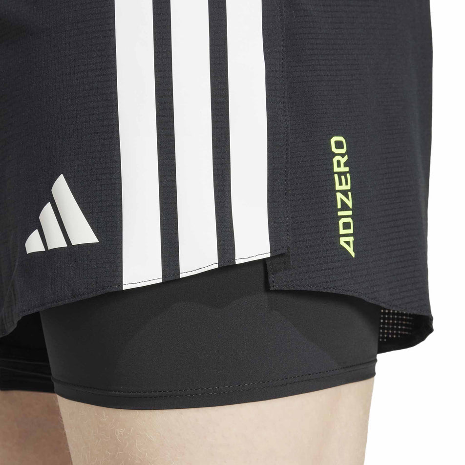 Close-up view of a model wearing the adidas Men's Adizero 2in1 Short in the Black colourway.  (8566982148258)