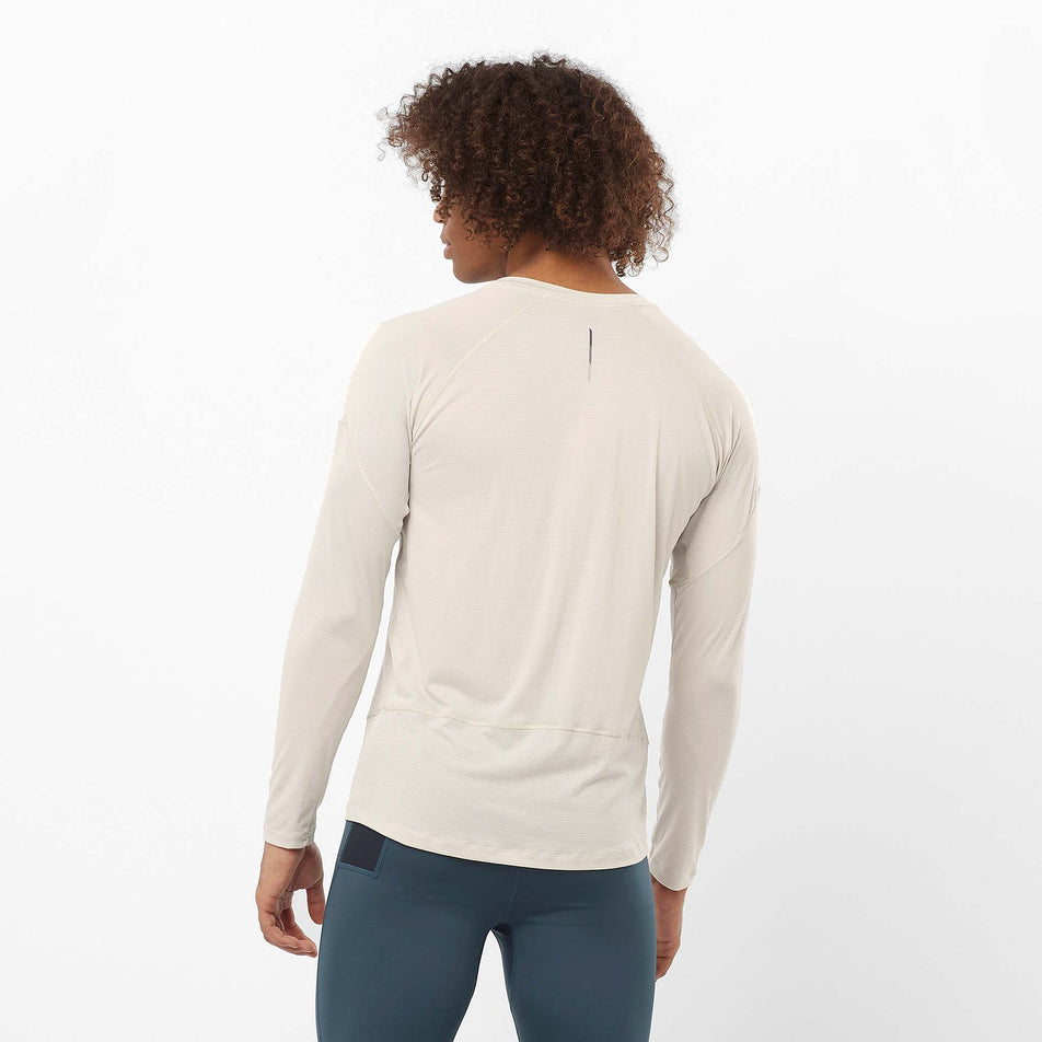 Back view of a model wearing the Salomon Men's Cross Run Long-Sleeve T-Shirt in the Rainy Day colourway. Model is also wearing leggings. (8509626220706)