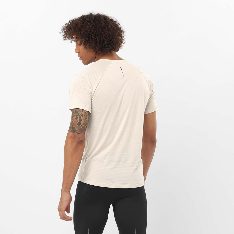 Back view of a model wearing the Salomon Men's Cross Run Short Sleeve Tee in the Rainy Day colourway. Model is also wearing leggings. (8509616652450)