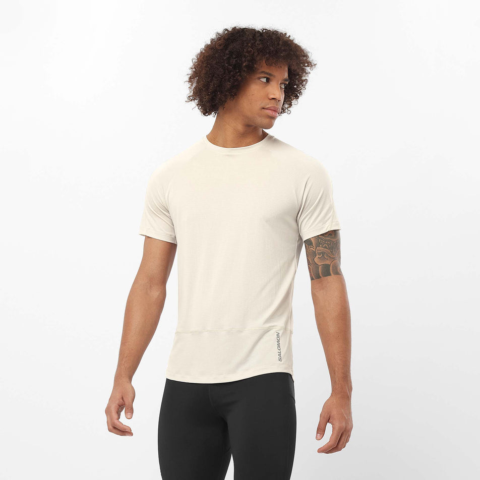 Front view of a model wearing the Salomon Men's Cross Run Short Sleeve Tee in the Rainy Day colourway. Model is also wearing leggings. (8509616652450)