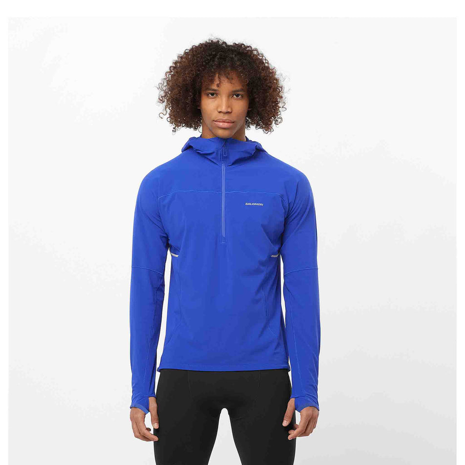 Front view of a model wearing a Salomon Men's Sense Aero Hybrid Midlayer Jacket with hood in the Surf The Web colourway. Model is also wearing legwear.  (8464251617442)