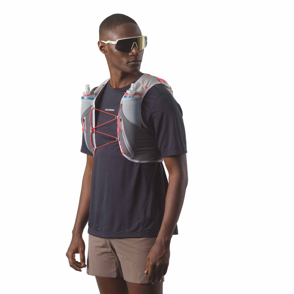 Front view of a model wearing the Salomon Unisex ADV Skin 12 Running Vest with flasks included in the Castlerock/Alloy/Neon Flame colourway. (8575889670306)