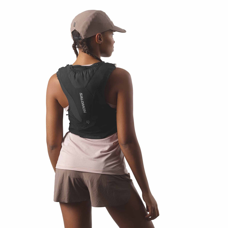 Back view of a model wearing the Salomon Unisex ADV Skin 5 Running Vest with flasks included in the Black colourway. (8575893307554)