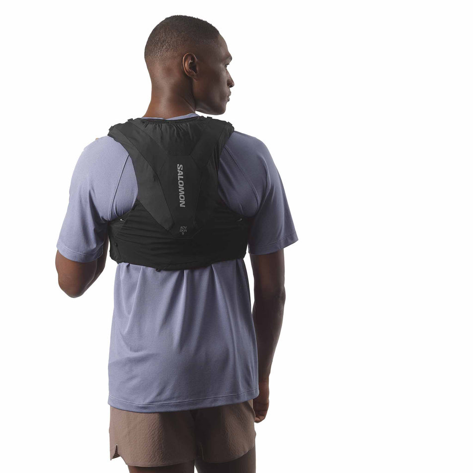 Back view of a model wearing the Salomon Unisex ADV Skin 5 Running Vest with flasks included in the Black colourway. (8575893307554)