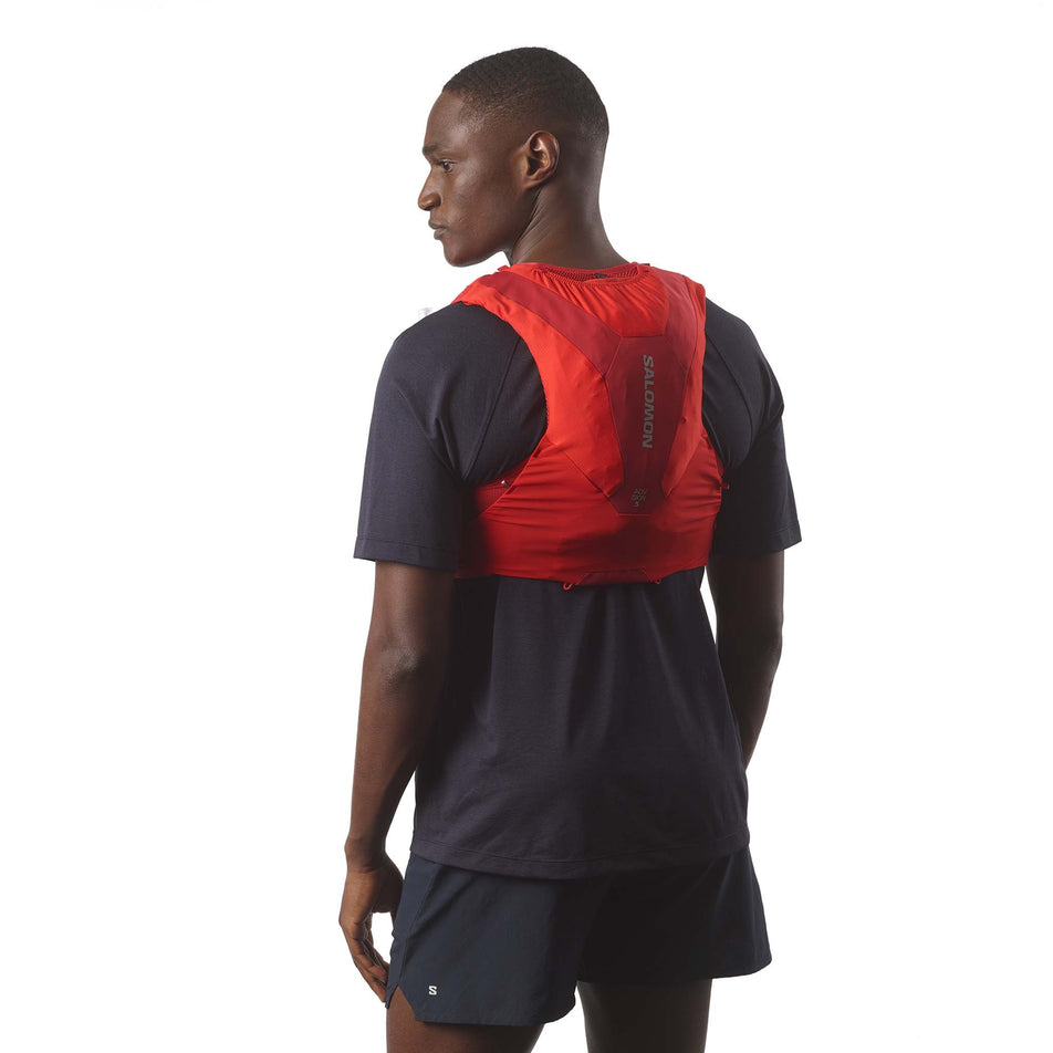 Back view of a model wearing the Salomon Unisex ADV Skin 5 Running Vest with flasks included in the Flame Scarlet/Haute Red colourway. (8575895306402)