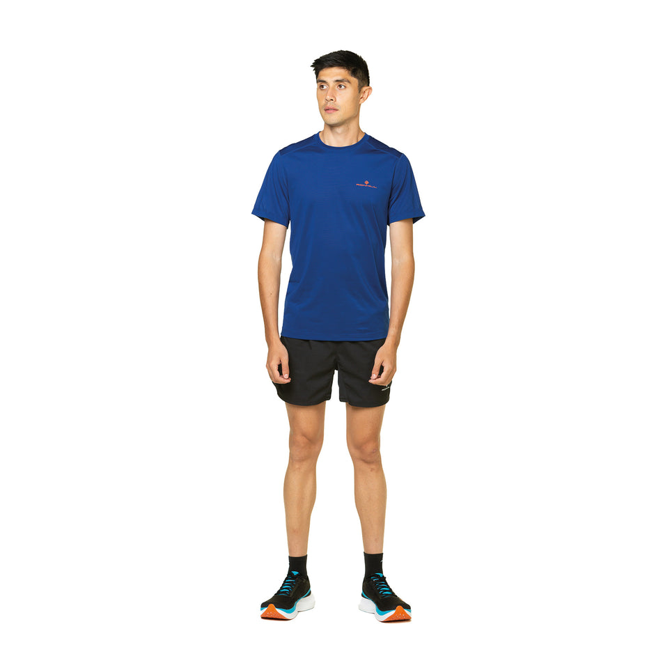 Front view of a model wearing the Ronhill Men's Tech S/S Tee in the Ocean/Cardinal Orange colourway. Model is also wearing Topo Athletic shoes, and Ronhill shorts and socks. (8491342332066)