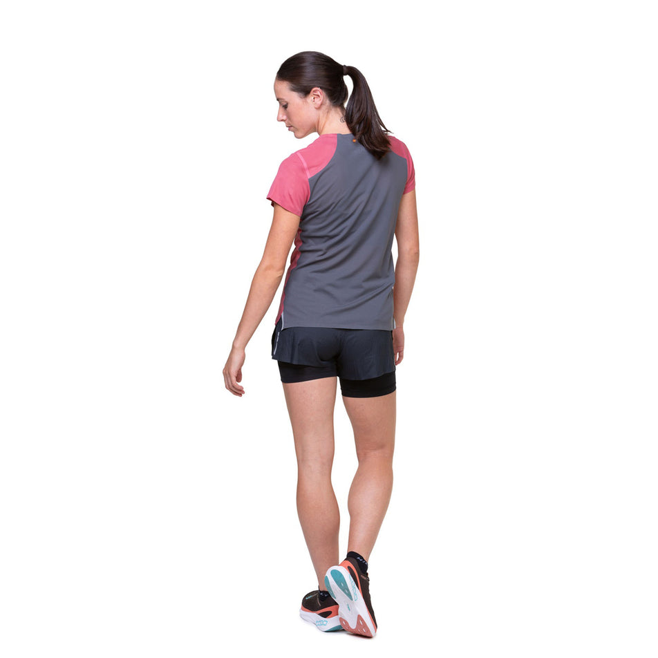 Back view of a model wearing the Ronhill Women's Tech Race S/S Tee in the Salsa/Iron colourway. Model is also wearing shorts, shoes and socks. (8469489516706)