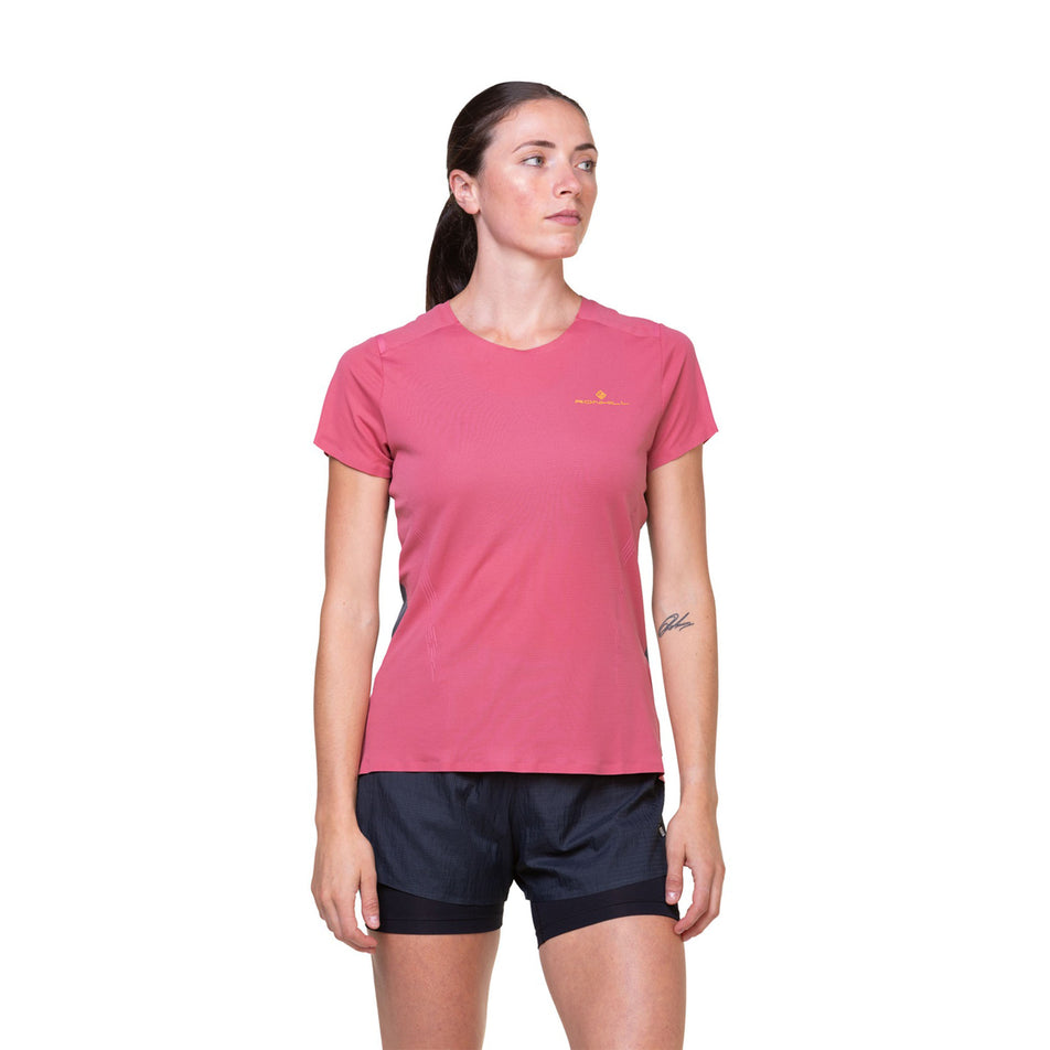 Front view of a model wearing the Ronhill Women's Tech Race S/S Tee in the Salsa/Iron colourway. Model is also wearing shorts. (8469489516706)