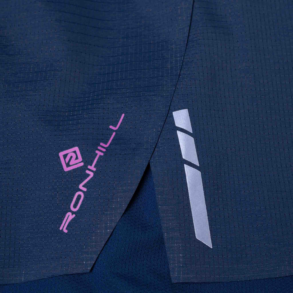 The Ronhill branding and reflective detail on the side of the Ronhill Women's Tech Race Twin Short in the Dark Navy/Razzmatazz colourway. (8583390822562)