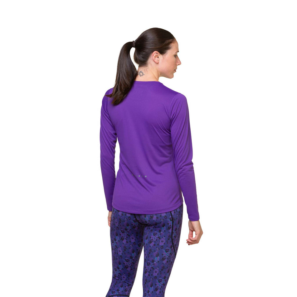 Back view of a model wearing a Ronhill Women's Core L/S Tee in the Regal Purple/Acid colourway. Model is also wearing leggings.  (8469578776738)