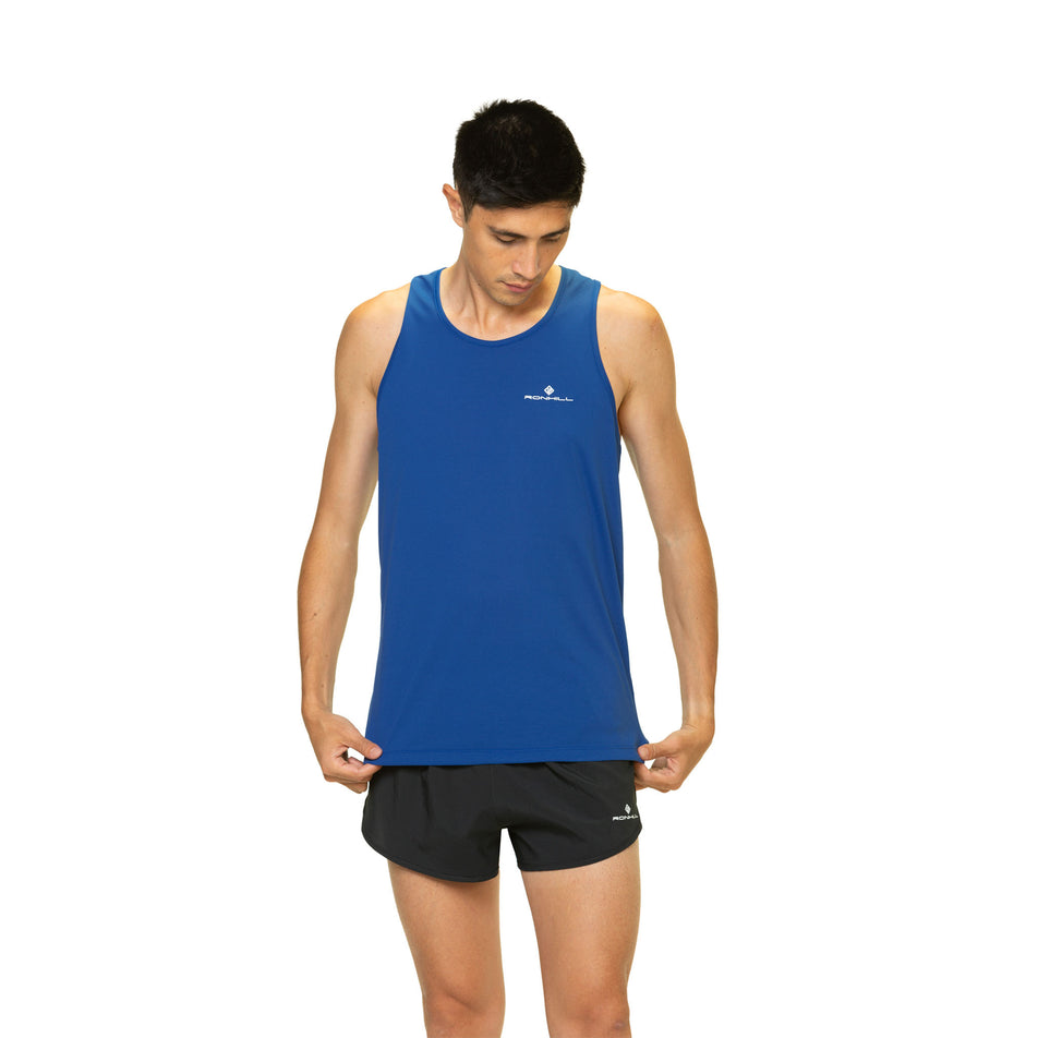 Front view of a model wearing a Ronhill Men's Core Vest in the Dark Cobalt/Bright White colourway. Model is also wearing shorts. (8470872752290)