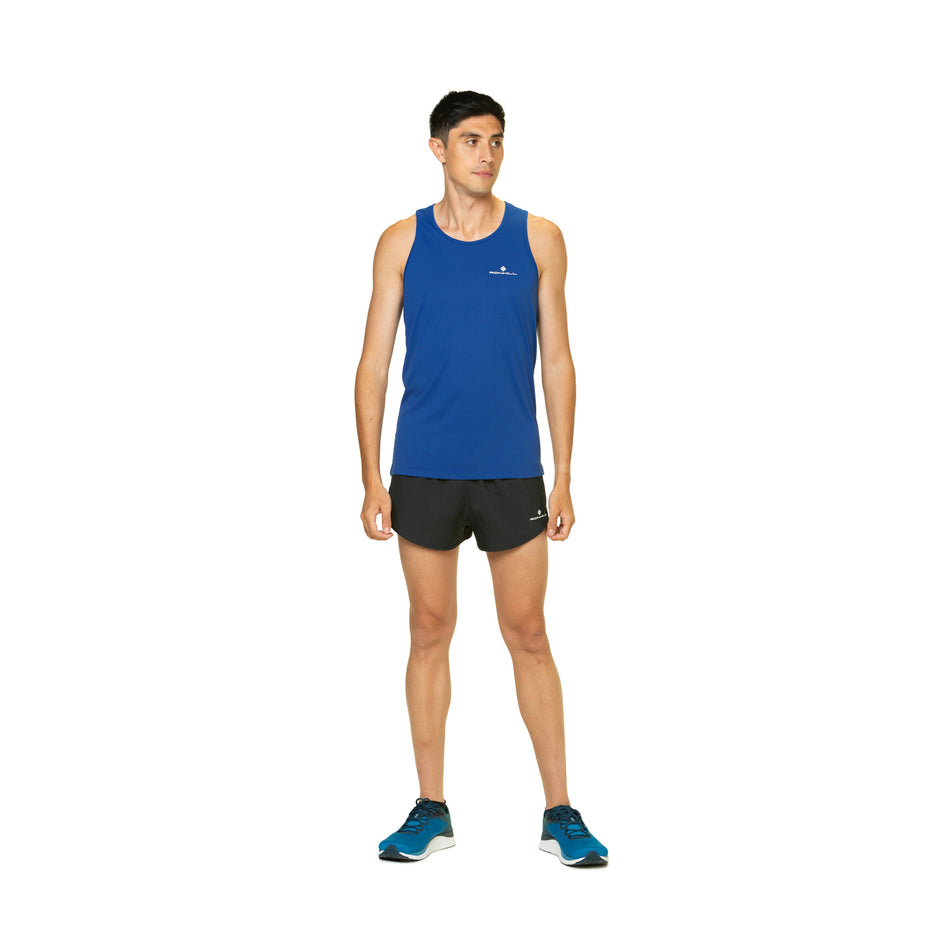 Front view of a model wearing a Ronhill Men's Core Vest in the Dark Cobalt/Bright White colourway. Model is also wearing shorts, socks and shoes. (8470872752290)