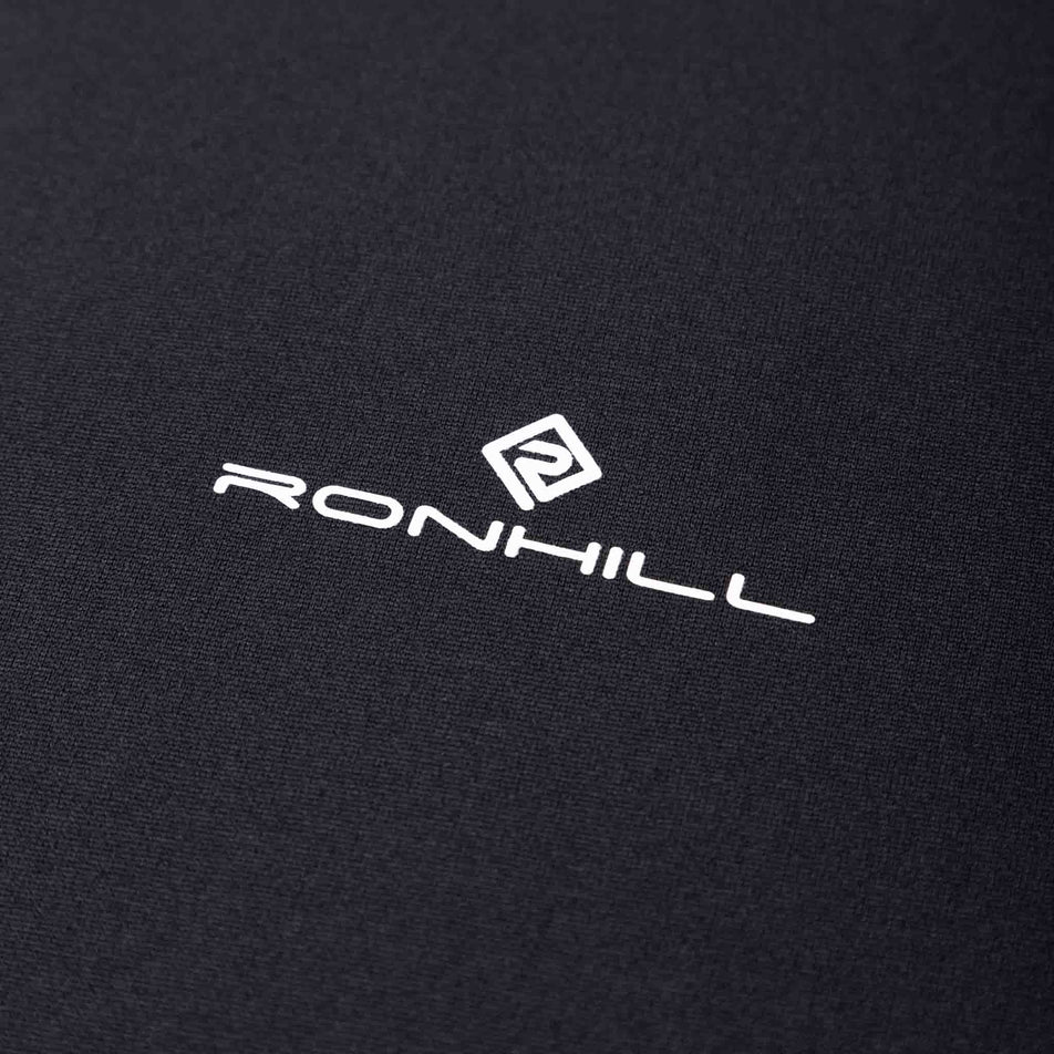 The Ronhill logo on a Ronhill Men's Core S/S Tee in the Black/Bright White colourway. (8490970120354)