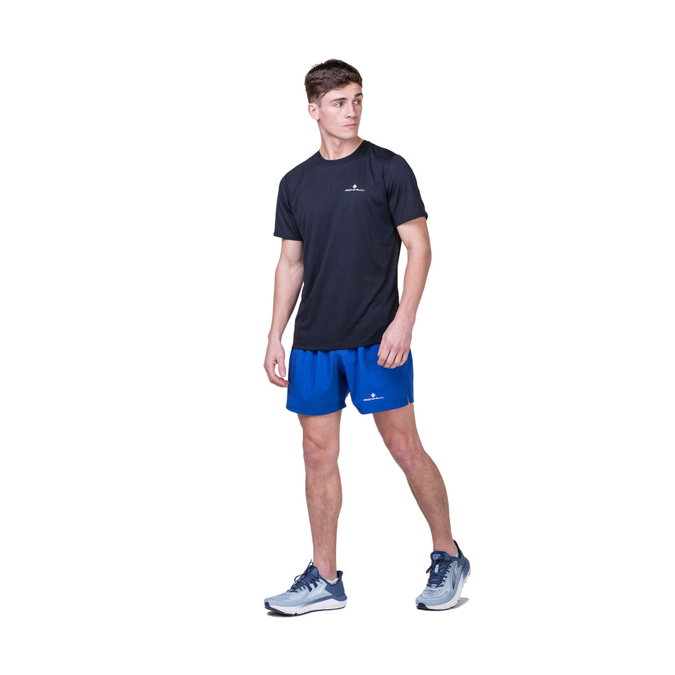 Front view of a model wearing the Ronhill Men's Core S/S Tee in the Black/Bright White colourway. Model is also wearing Ronhill shorts and Altra shoes. (8490970120354)