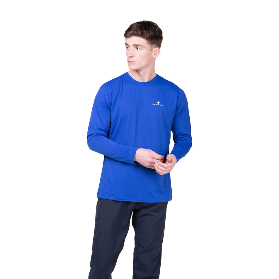 Front view of a model wearing a Ronhill Men's Core L/S Tee in the Dark Cobalt/Bright White colourway. Model is also wearing legwear. (8468452049058)