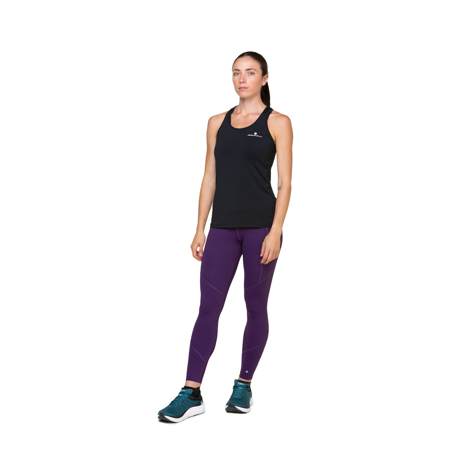 Front view of a model wearing the Ronhill Women's Tech Tight in the Damson colourway. Model is also wearing shoes and a top. (8489979510946)