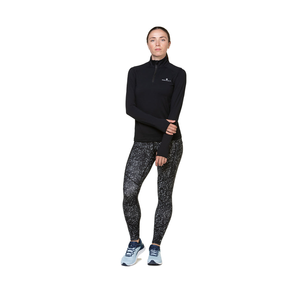 Front view of a model wearing the Ronhill Women's Tech Tight in the Mono Sprinkle colourway. Model is also wearing shoes and a top. (8490012737698)