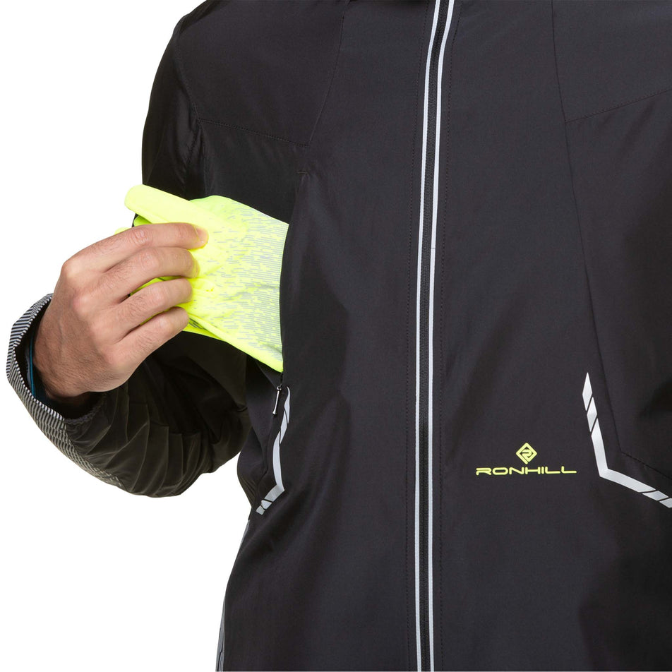 A model demonstrating that gloves can be stored in the chest pocket of a Ronhill Men's Tech Reflect Jacket. Jacket is being worn by the model. (8490194731170)