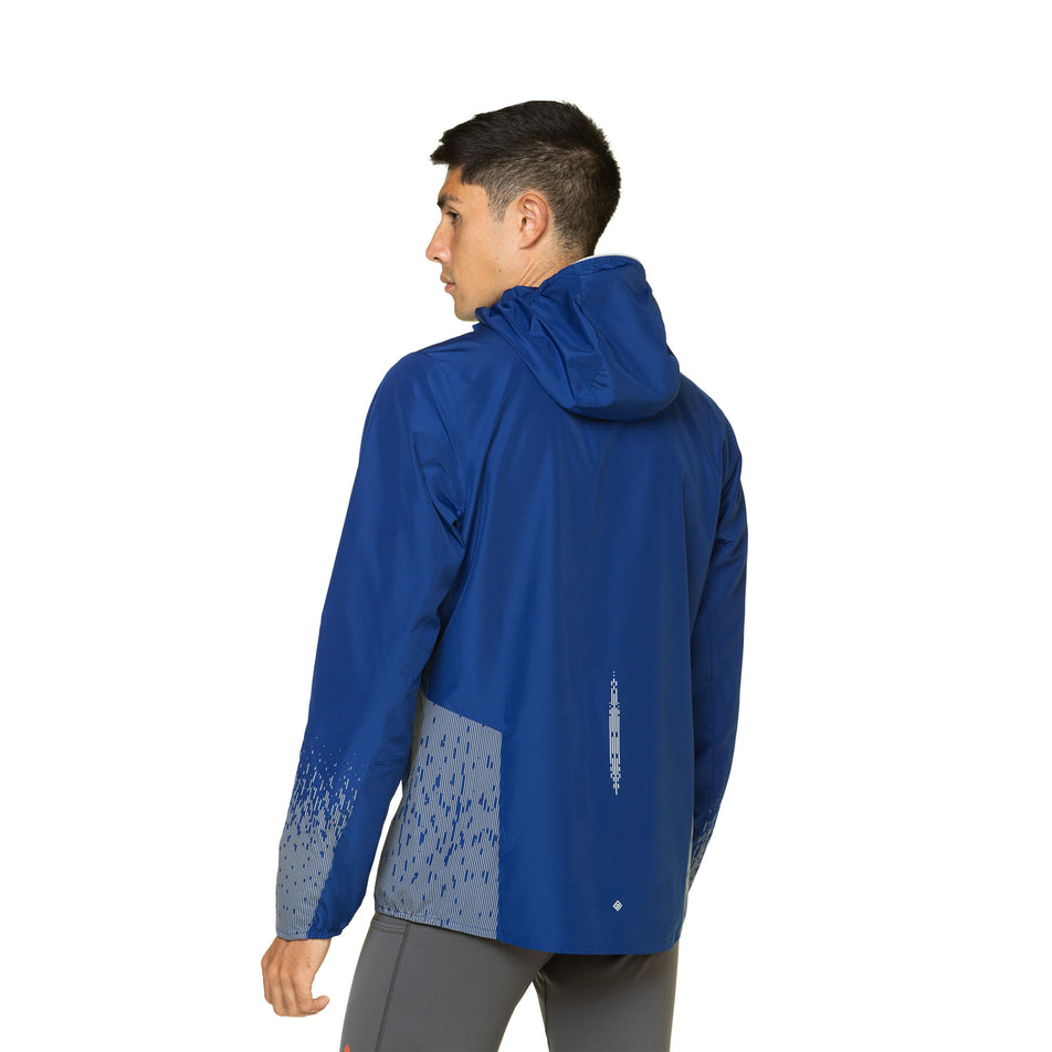 Back view of a model wearing a Ronhill Men's Tech Reflect Jacket in the Ocean/Reflect colourway. Model is also wearing leggings. (8469614395554)