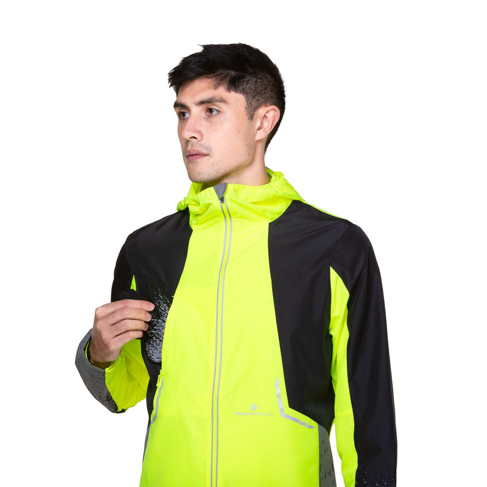 A model demonstrating that gloves can be stored in the chest pocket of a Ronhill Men's Tech Reflect Jacket. Jacket is being worn by the model. (8490189095074)