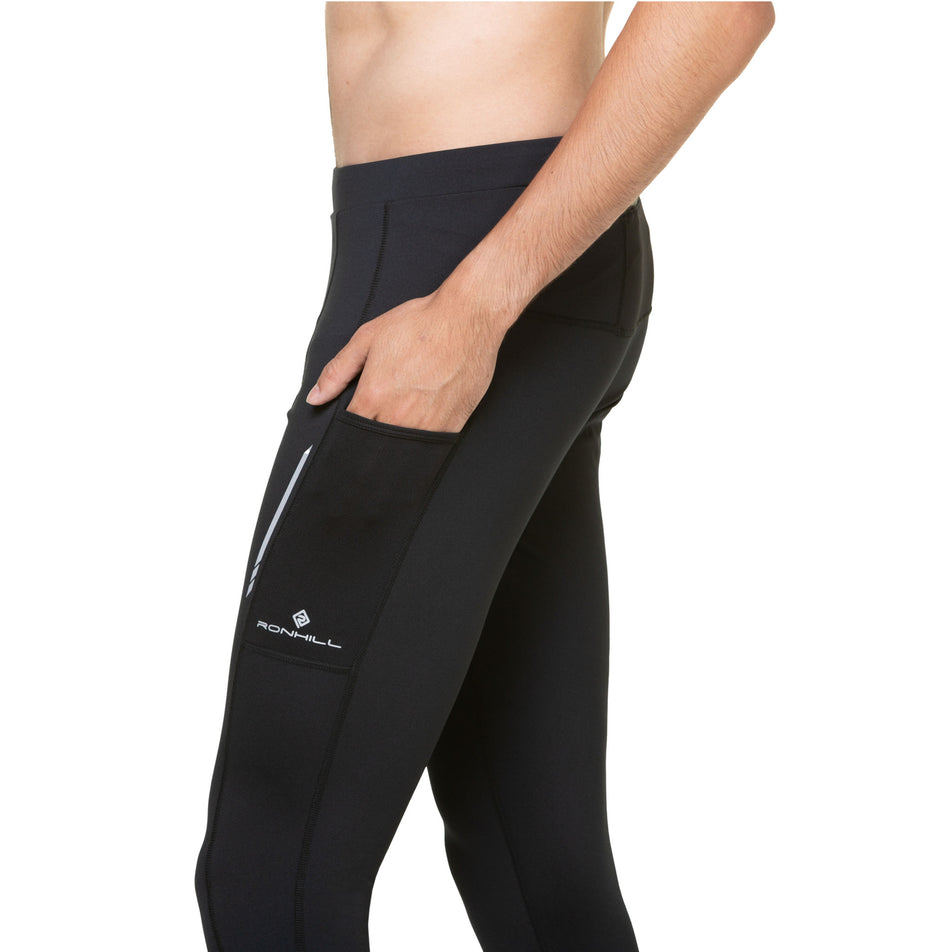 A model highlighting the stretch pocket on the outside of the left leg of the Ronhill Men's Tech Reflect Tight. Tights are being worn by a model. (8469653848226)