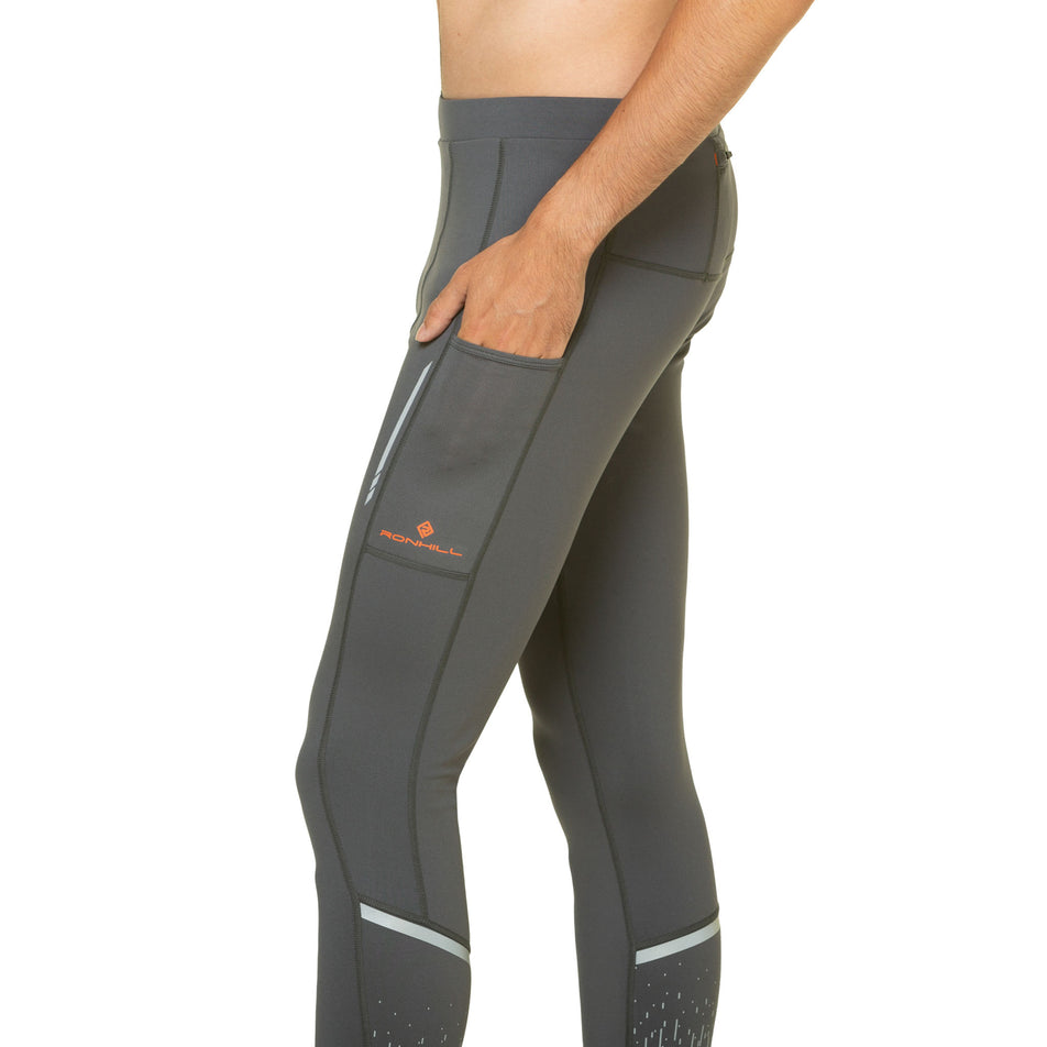 A model demonstrating the side pocket on the left-thigh of the Ronhill Men's Tech Reflect Tight in the Iron/Reflect colourway. (8490232447138)