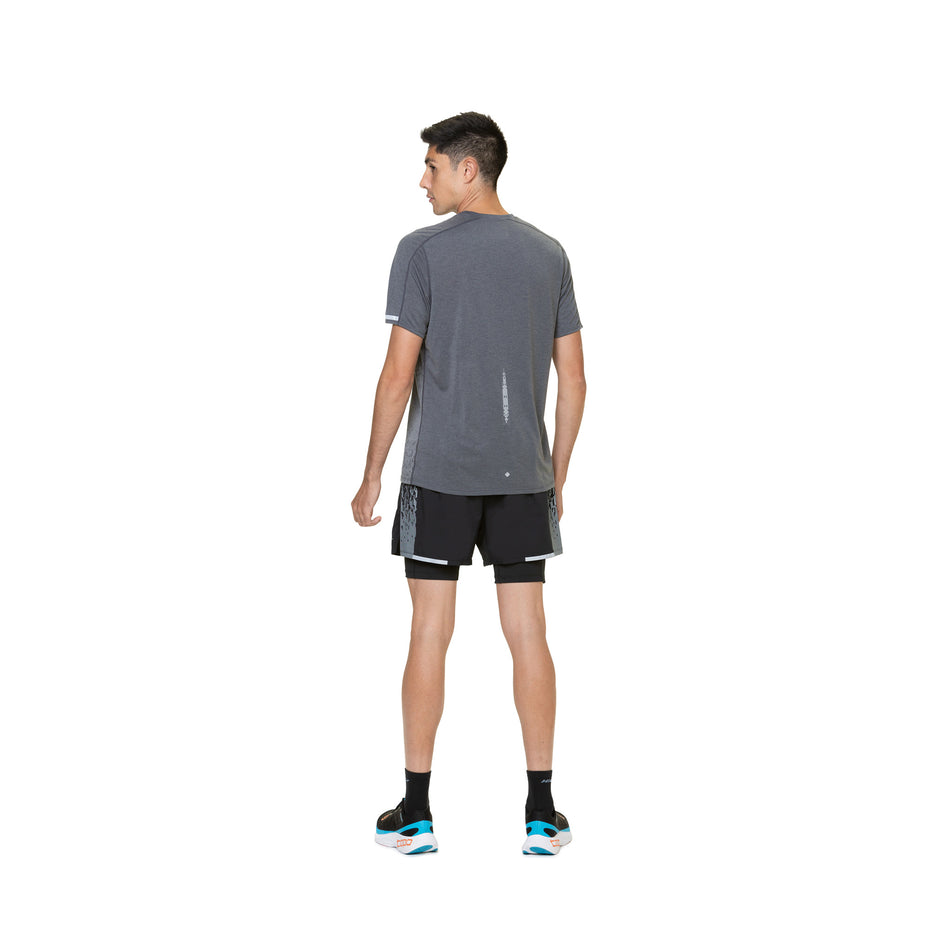 Back view of a model wearing a Ronhill Men's Tech Reflect S/S Tee in the Iron/Reflect colourway. Model is also wearing socks, shoes and shoes. (8490228940962)