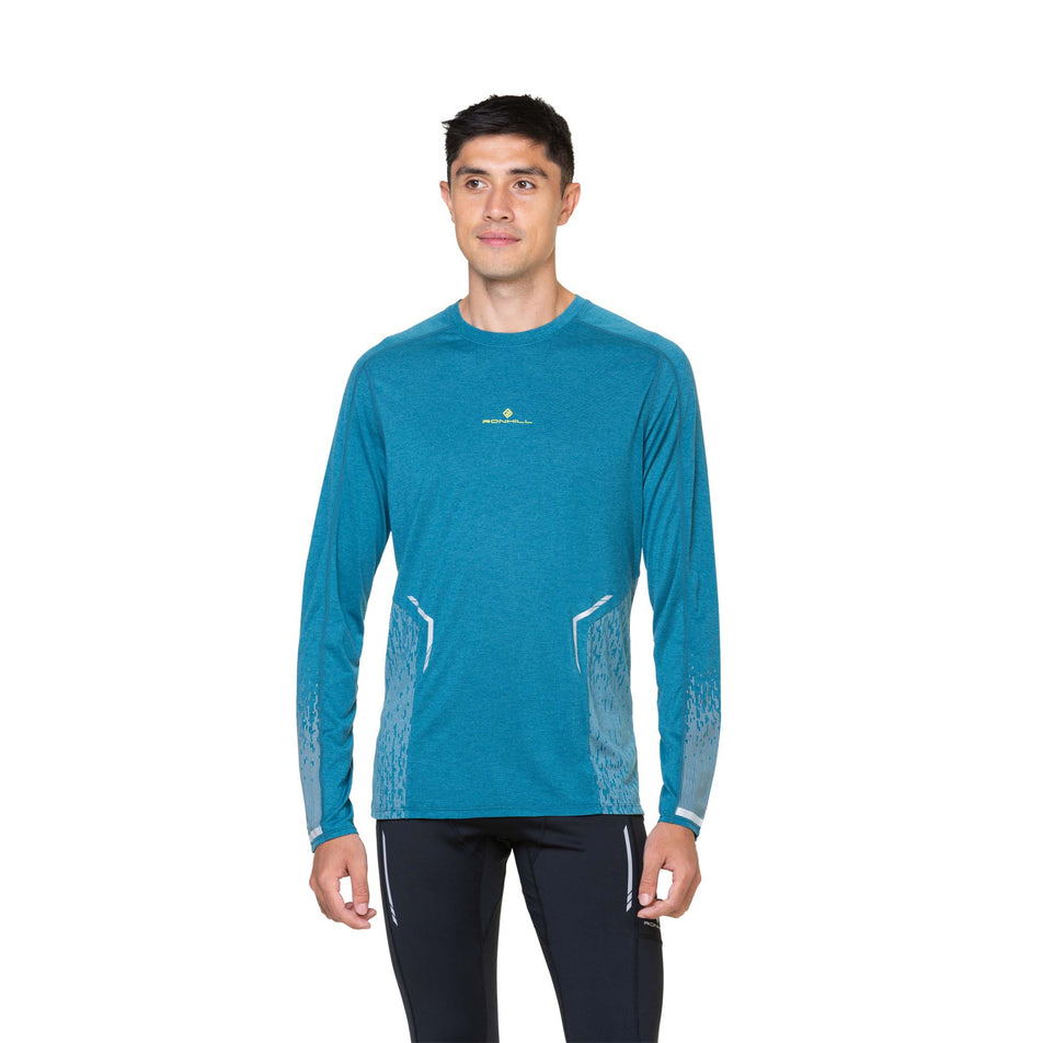 Front view of a model wearing a Ronhill Men's Tech Reflect L/S Tee in the Deep Teal/Reflect colourway. (8490211573922)