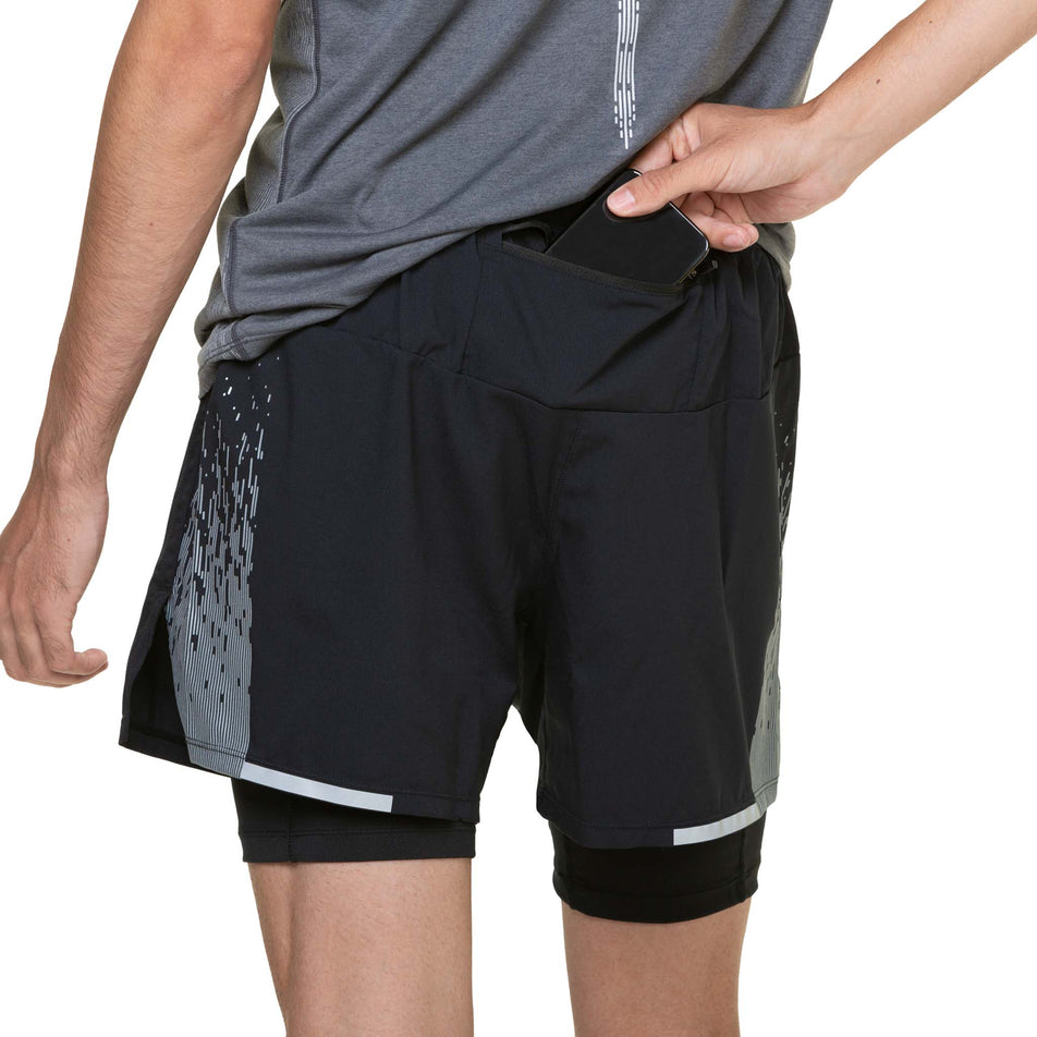 A model highlighting the zipped back pocket on the Ronhill Men's Tech Reflect 5