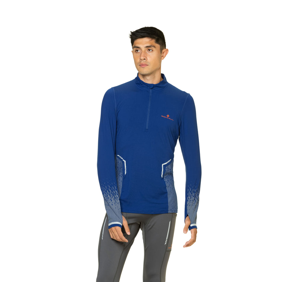 Front view of a model wearing a Ronhill Men's Tech Reflect 1/2 Zip in the Ocean/Reflect colourway. Model is also wearing leggings. (8469639135394)