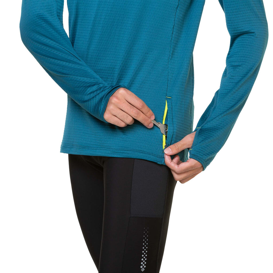 A model demonstrating that a key can be stored in the zip pocket on a Ronhill Men's Tech Winter 1/2 Zip. Top is being worn by the model - who is also wearing leggings. (8490264068258)