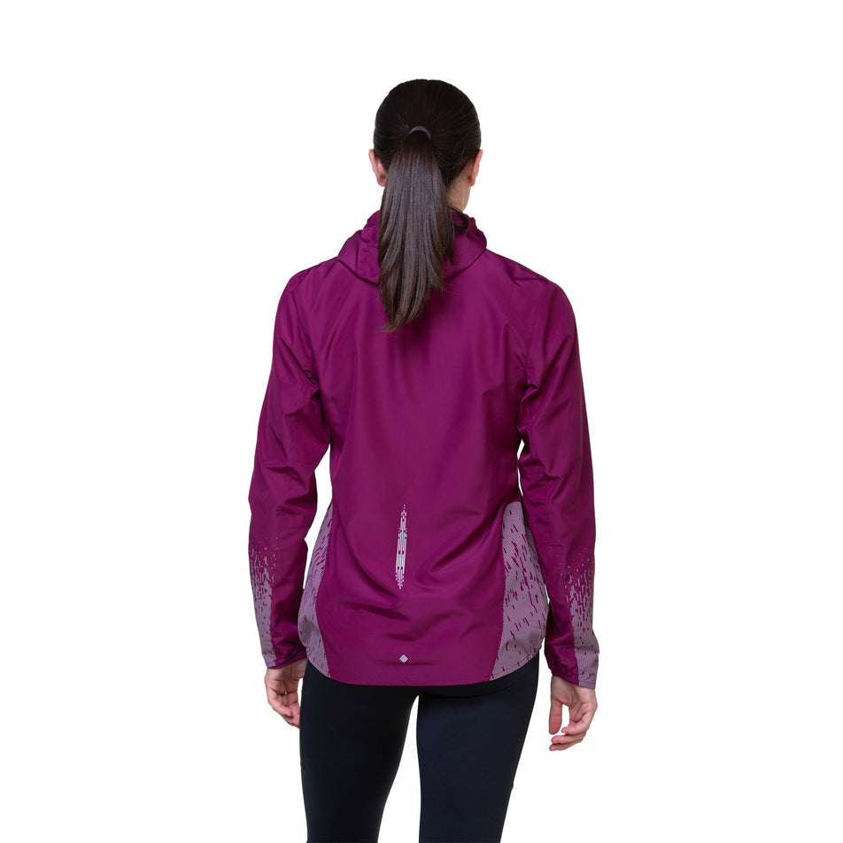 Back view of a model wearing a Ronhill Women's Tech Reflect Jacket in the Blackcurrant/Reflect colourway. Model is also wearing tights. (8489670607010)