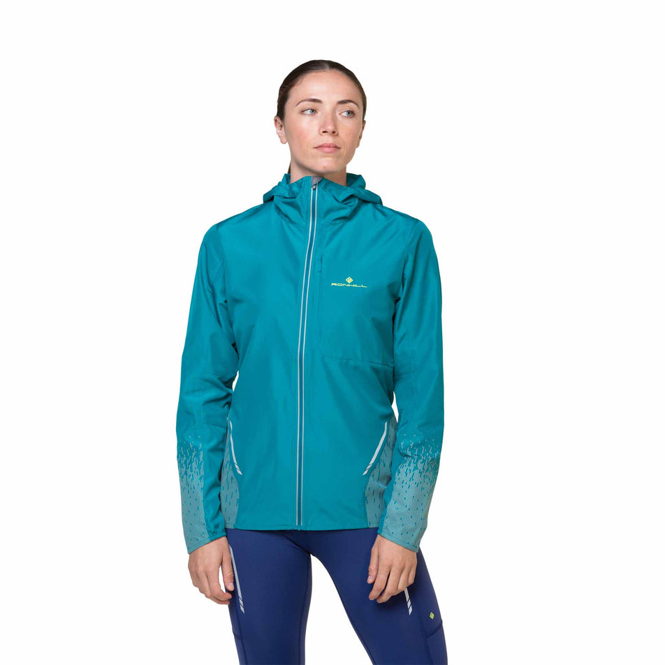 Front view of a model wearing a Ronhill Women's Tech Reflect Jacket in the Marine/Reflect colourway. Model is also wearing leggings.  (8469205090466)