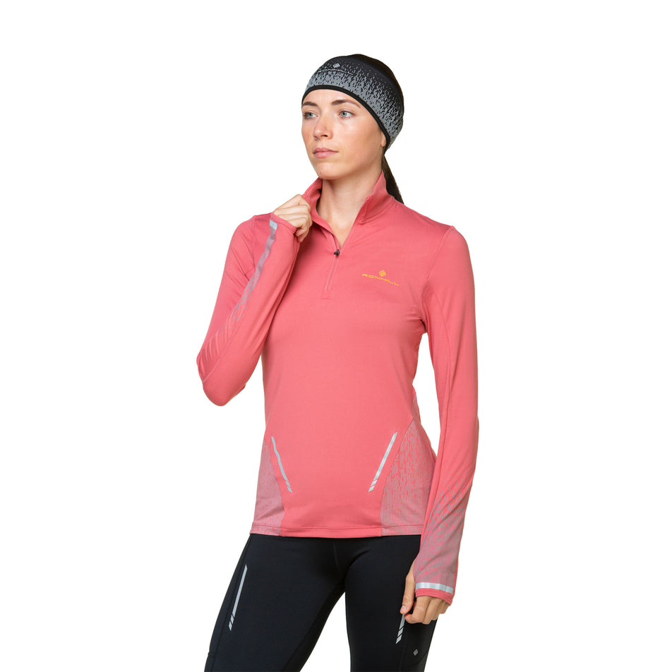 Front view of a model wearing a Ronhill Women's Tech Reflect 1/2 Zip in the Salsa/Reflect colourway. Model is also wearing leggings and a headband.  (8469213249698)