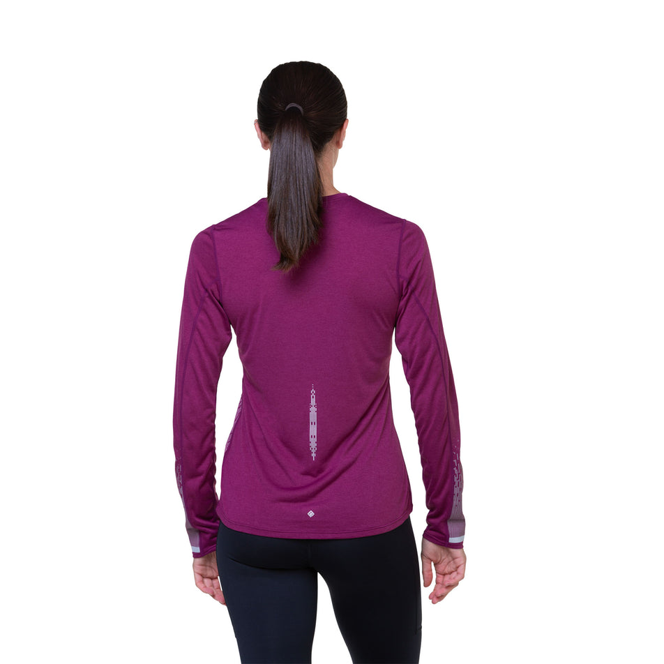 Back view of a model wearing a Ronhill Women's Tech Reflect L/S Tee in the Blackcurrant/Reflect colourway. Model is also wearing tights. (8489740435618)