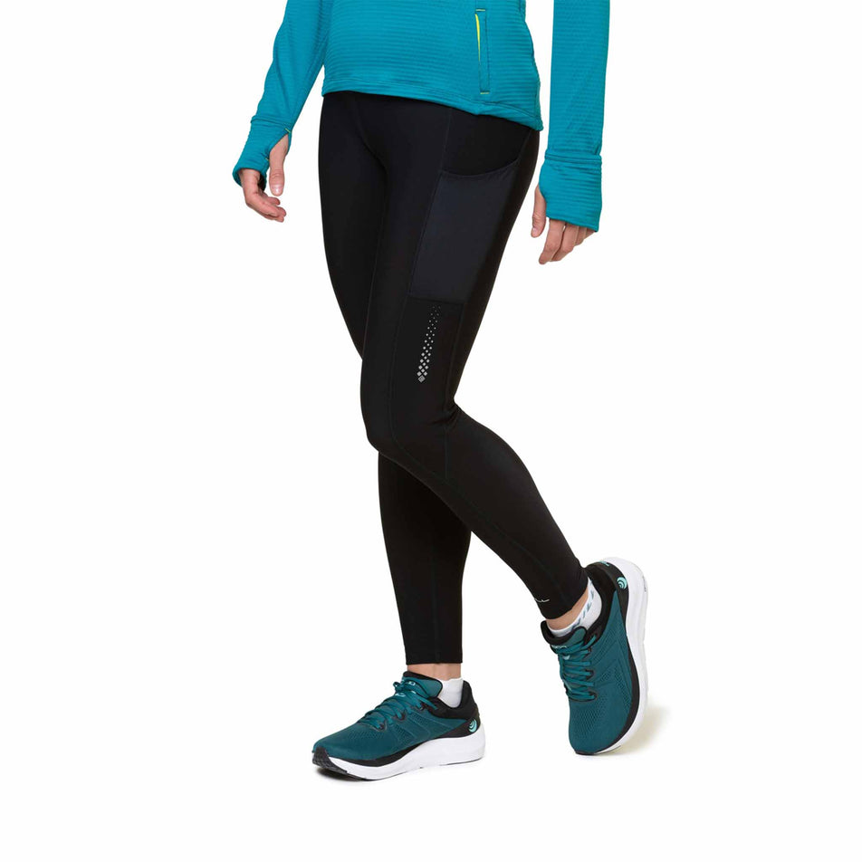 Front view of a model wearing the Ronhill Women's Tech Winter Tight in the All Black colourway. Model is also wearing shoes and a top. (8491198480546)