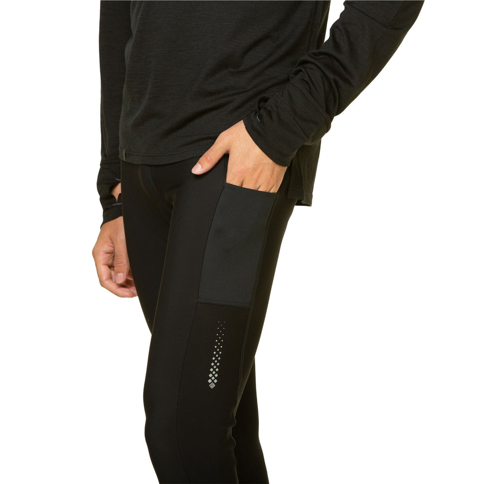 A model highlighting the stretch pocket on the outside of the Ronhill Men's Tech Winter Tights' left leg.  (8491238686882)