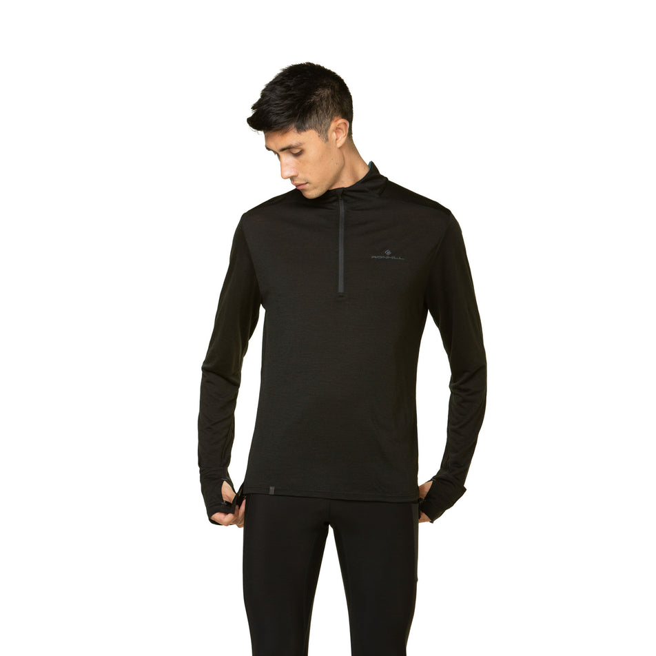 Front view of a model wearing the Ronhill Men's Tech Merino 1/2 Zip in the Black/Lake colourway. Model is also wearing leggings. (8490269573282)