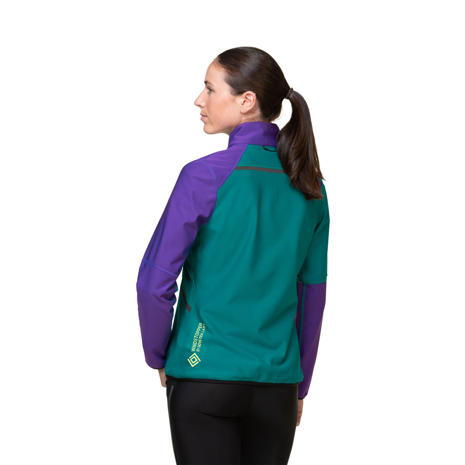 A model demonstrating that gloves can be stored in the chest pocket of a Ronhill Women's Tech GORE-TEX Windstopper Jacket. (8489773990050)